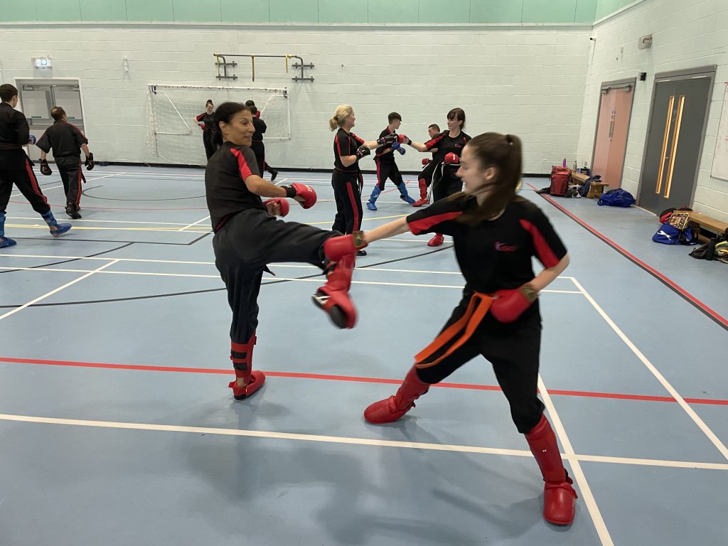 Two students sparring in protective gear