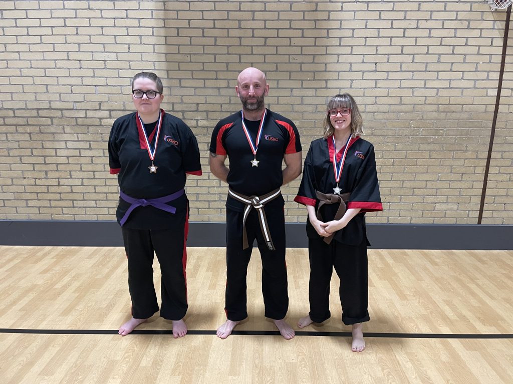 Three students wearing their grading medals