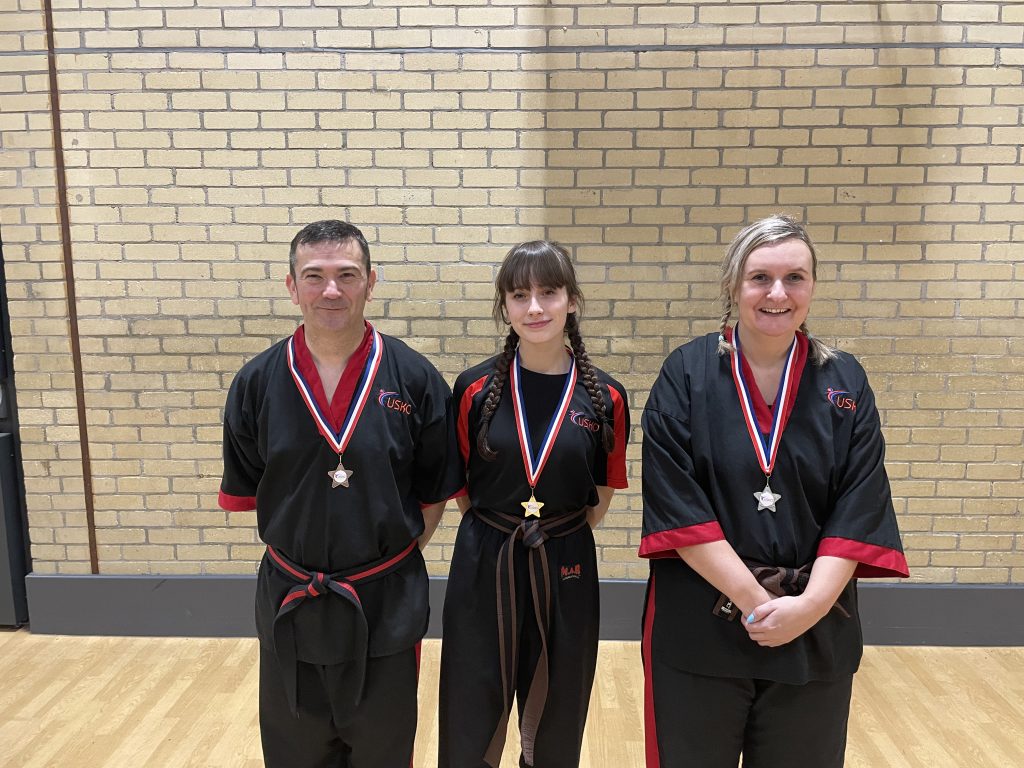 Three students wearing their grading medals